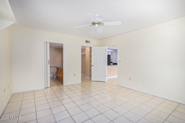 tiled spare room featuring ceiling fan and a textured ceiling