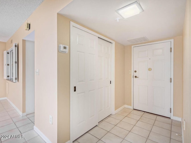 tiled foyer with a textured ceiling