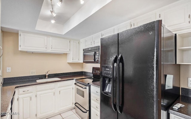 kitchen featuring black appliances, sink, a tray ceiling, white cabinetry, and light tile patterned floors