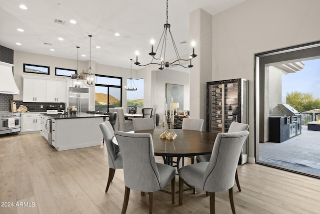 dining space with an inviting chandelier and light wood-type flooring