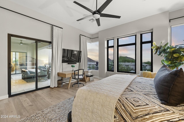 bedroom featuring ceiling fan, light hardwood / wood-style floors, and access to exterior