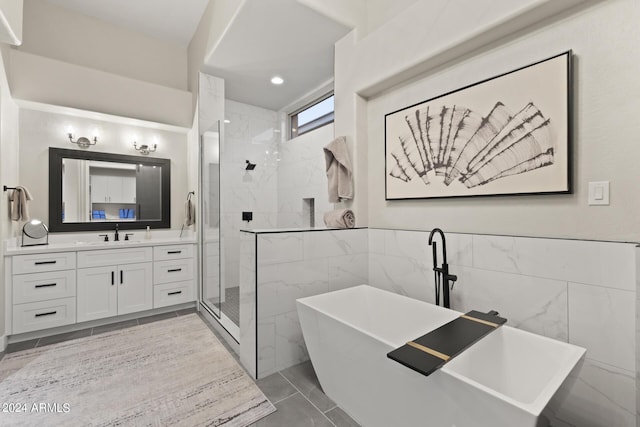 bathroom with tile walls, separate shower and tub, and vanity