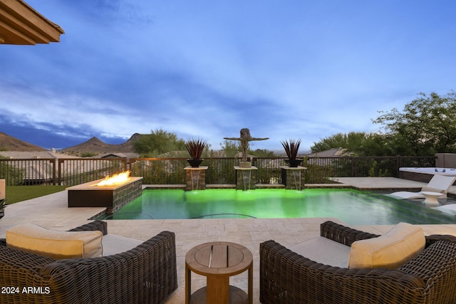 view of pool with a fire pit, a patio area, and a mountain view