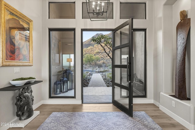 doorway with an inviting chandelier and hardwood / wood-style flooring