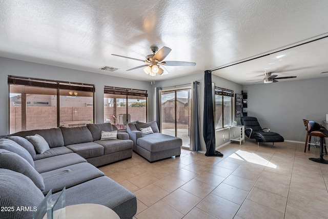 13547 W Peck Dr, Litchfield Park, AZ 85340 - living room featuring visible vents, light tile patterned flooring, ceiling fan, a textured ceiling, and baseboards
