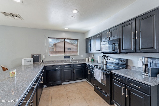 kitchen featuring light tile patterned floors, visible vents, dark cabinets, black appliances, and a sink