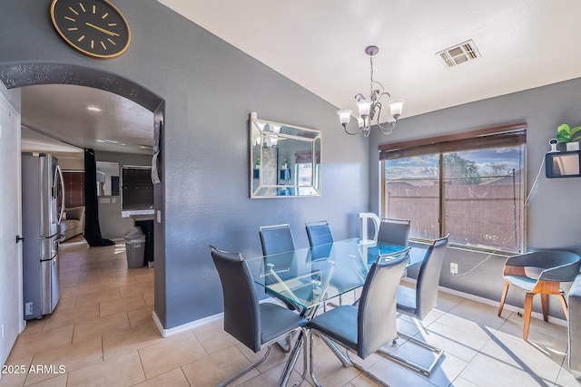13547 W Peck Dr, Litchfield Park, AZ 85340 - tiled dining space featuring visible vents, arched walkways, baseboards, lofted ceiling, and a chandelier