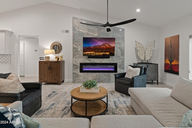 living room featuring lofted ceiling, a high end fireplace, and ceiling fan