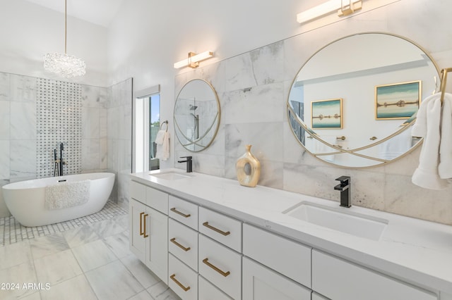 bathroom with vanity, tile walls, an inviting chandelier, and a bath