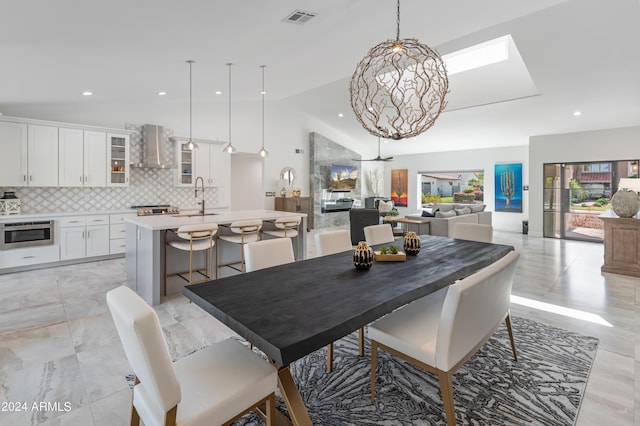 dining space featuring lofted ceiling, an inviting chandelier, and sink