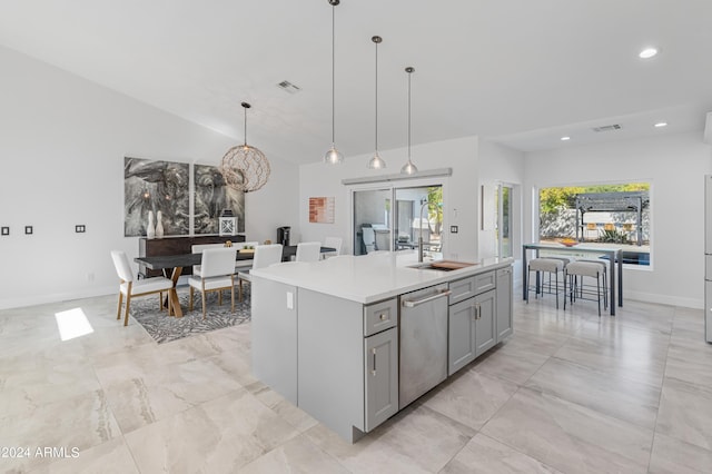 kitchen featuring stainless steel dishwasher, decorative light fixtures, lofted ceiling, a kitchen island with sink, and gray cabinets