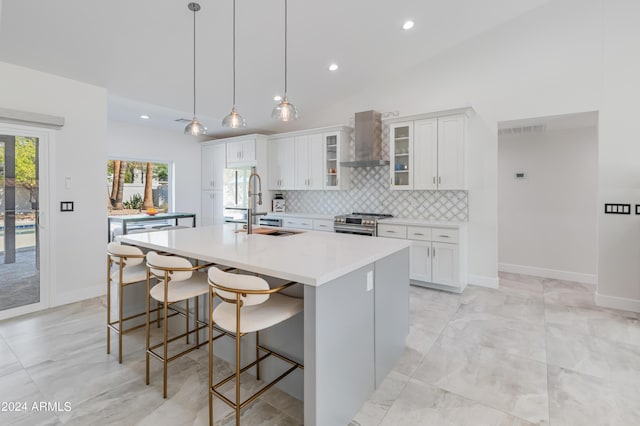 kitchen featuring a center island with sink, white cabinets, and wall chimney exhaust hood