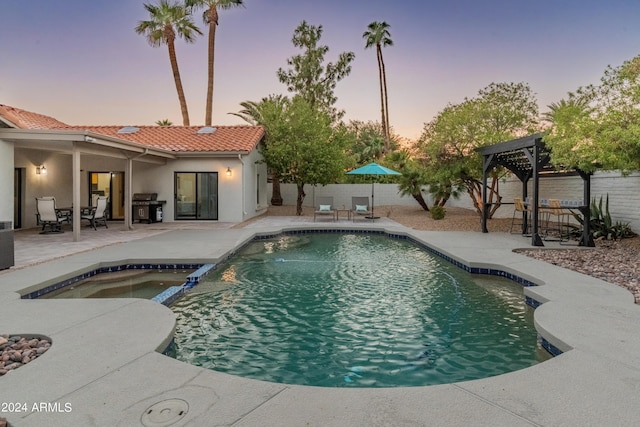 pool at dusk featuring a pergola, a grill, an in ground hot tub, and a patio