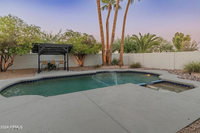 pool at dusk featuring an in ground hot tub, a patio area, and a pergola