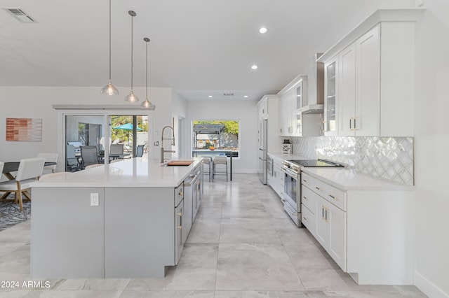 kitchen featuring sink, white cabinetry, hanging light fixtures, a center island with sink, and appliances with stainless steel finishes