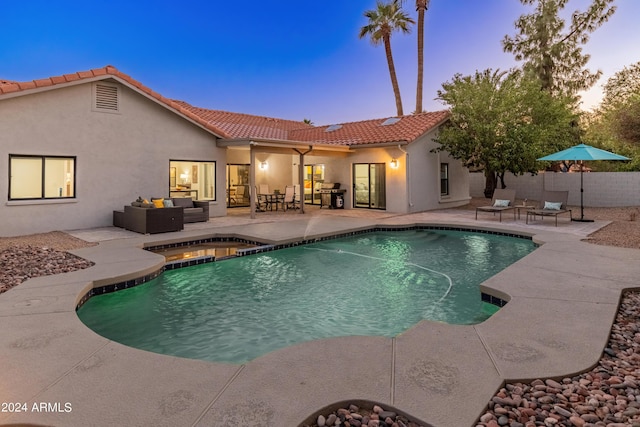 pool at dusk with a patio and outdoor lounge area