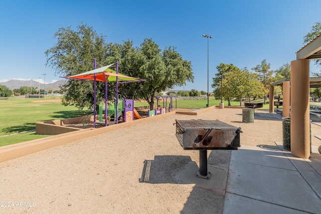 view of home's community featuring a yard, a playground, and a mountain view