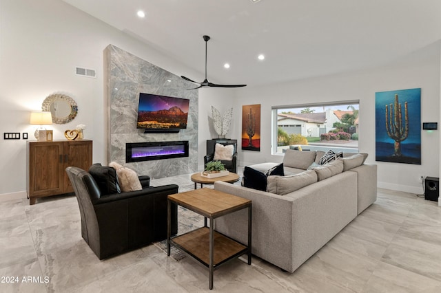 living room featuring ceiling fan and a premium fireplace