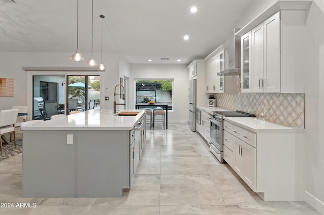 kitchen featuring sink, white cabinetry, a center island with sink, pendant lighting, and appliances with stainless steel finishes