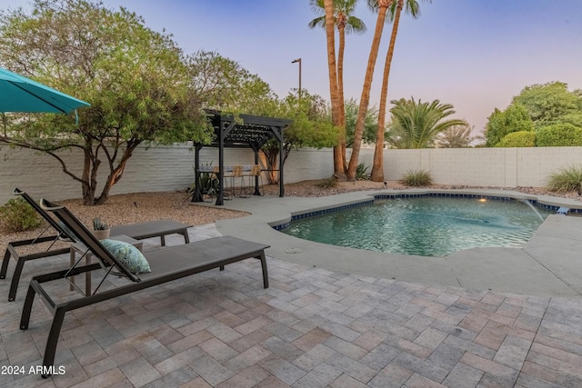 pool at dusk with a patio, pool water feature, and a pergola