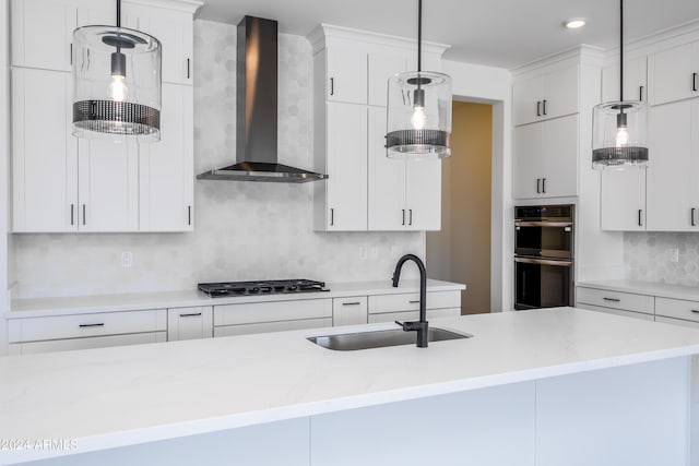 kitchen with a sink, gas cooktop, double oven, wall chimney exhaust hood, and decorative backsplash