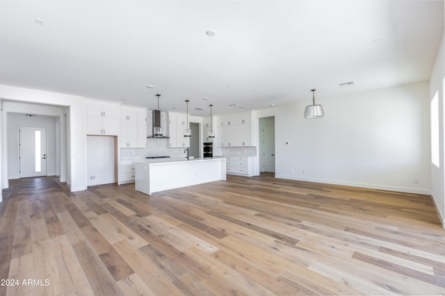 unfurnished living room with light wood-type flooring and sink