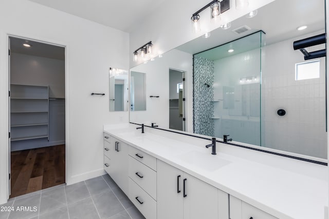 bathroom featuring vanity, wood-type flooring, and tiled shower