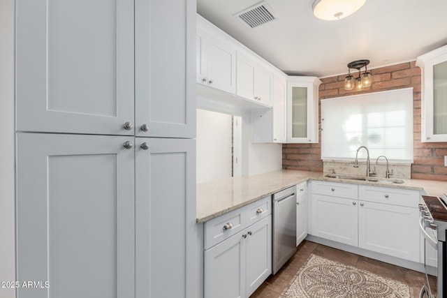 kitchen with visible vents, white cabinets, light stone counters, a sink, and stainless steel appliances