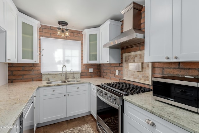 kitchen featuring a sink, decorative backsplash, wall chimney range hood, and stainless steel appliances
