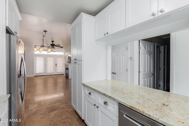 kitchen with stainless steel fridge, a ceiling fan, white cabinetry, and light stone counters
