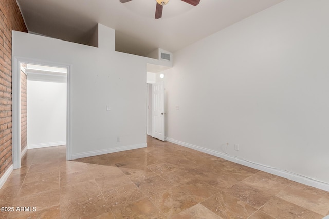unfurnished room featuring ceiling fan, stone finish flooring, visible vents, baseboards, and high vaulted ceiling