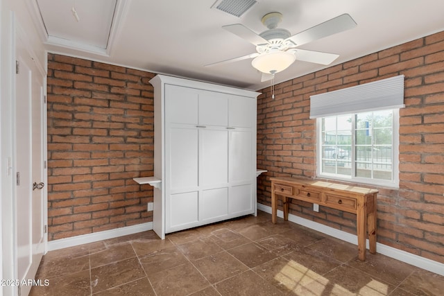 unfurnished bedroom featuring a closet, visible vents, brick wall, baseboards, and ceiling fan