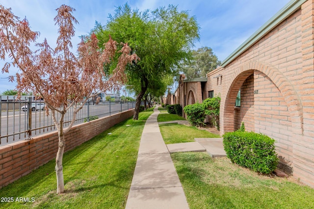 view of home's community featuring fence and a lawn