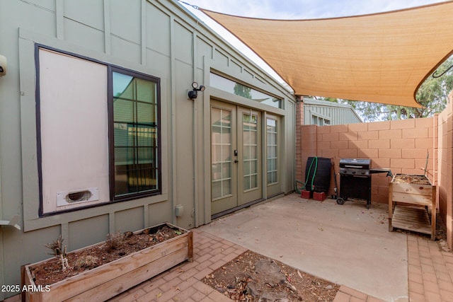 view of patio / terrace featuring area for grilling, fence, and french doors