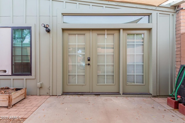 entrance to property featuring board and batten siding, french doors, and a patio area