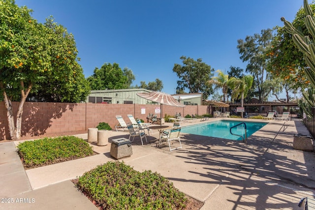 community pool featuring fence and a patio