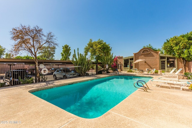 pool with a patio and fence