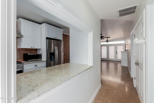 kitchen with a ceiling fan, visible vents, light stone countertops, baseboards, and stainless steel appliances