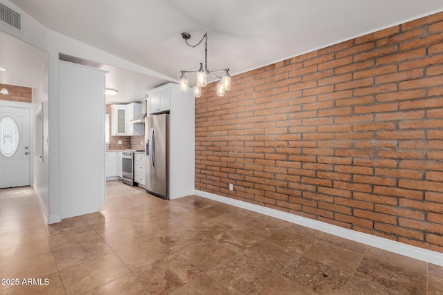 interior space with visible vents, baseboards, and brick wall