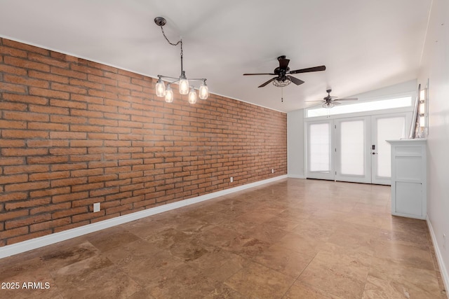 spare room with baseboards, a ceiling fan, and brick wall