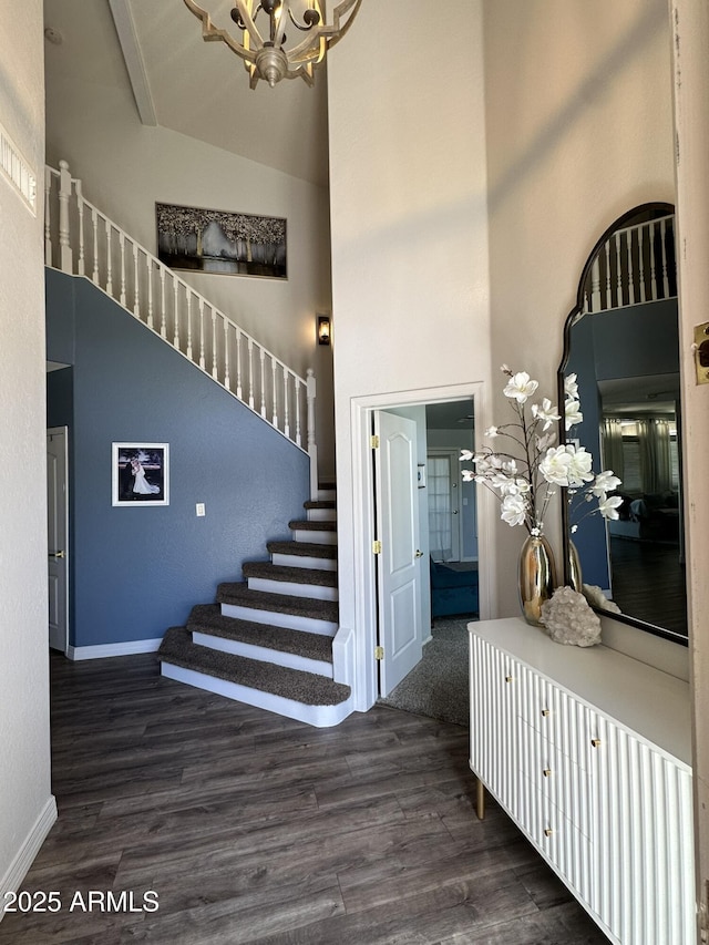 entrance foyer with high vaulted ceiling, a chandelier, dark wood finished floors, baseboards, and stairway