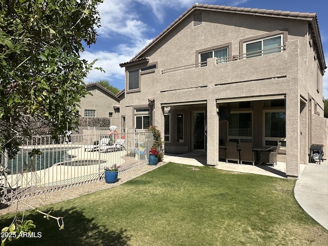 back of house with a yard, fence, a patio area, and stucco siding