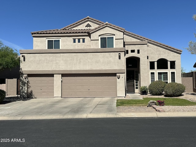 view of front of property featuring concrete driveway, a tiled roof, an attached garage, and stucco siding