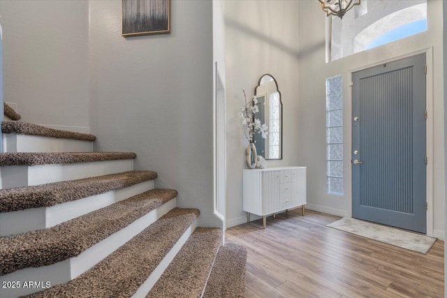 foyer entrance with stairs, a wealth of natural light, and wood finished floors