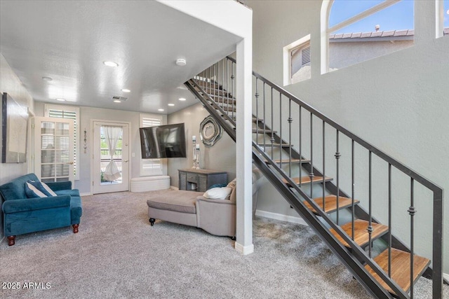 carpeted living area featuring stairway, baseboards, recessed lighting, and visible vents