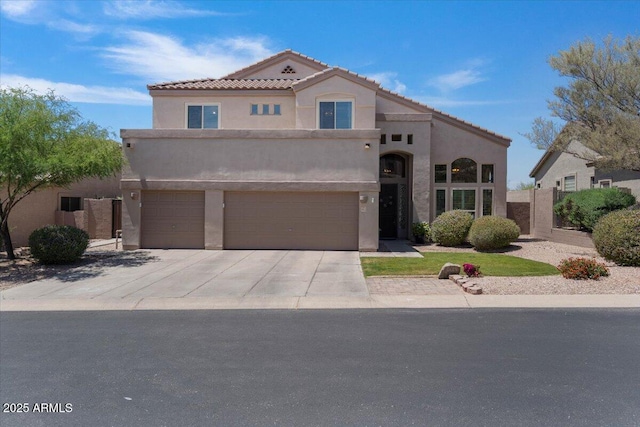 mediterranean / spanish home featuring an attached garage, stucco siding, concrete driveway, and a tiled roof
