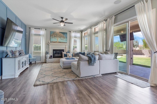 living room featuring a ceiling fan, a healthy amount of sunlight, and wood finished floors