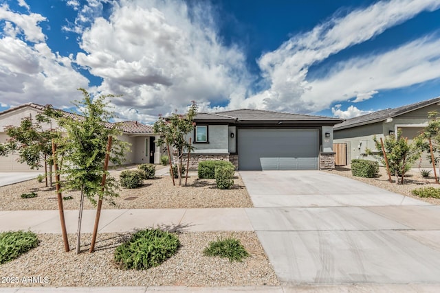 17376 W Via De Luna Dr, Surprise, AZ 85387 - view of front of home with a tile roof, stone siding, a garage, stucco siding, and driveway