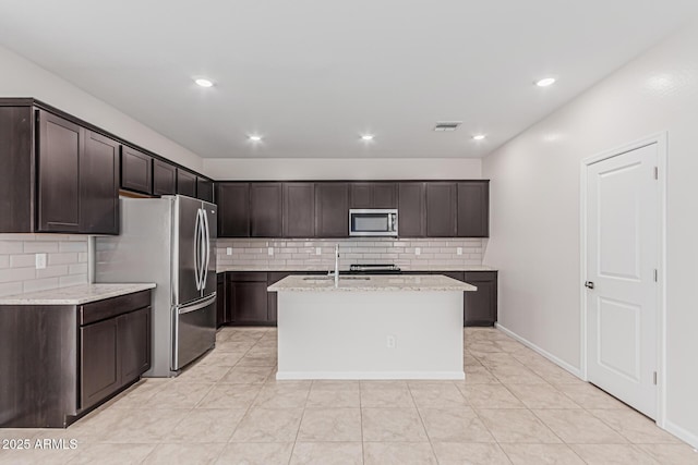 17376 W Via De Luna Dr, Surprise, AZ 85387 - kitchen featuring dark brown cabinetry, backsplash, visible vents, light stone countertops, and stainless steel appliances