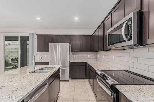 17376 W Via De Luna Dr, Surprise, AZ 85387 - kitchen featuring dark brown cabinetry, light stone counters, a sink, stainless steel appliances, and tasteful backsplash